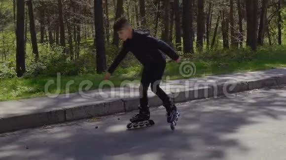 夏天公园里穿着皮夹克的时髦少年骑着溜冰鞋视频的预览图