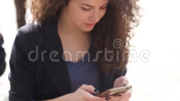 美丽的年轻女子手里拿着智能手机视频的预览图