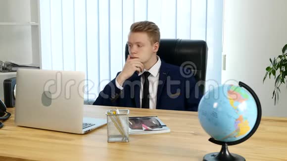 一个忧郁的年轻人坐在办公室工作视频的预览图