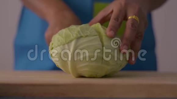 近镜头的女人手切卷心菜在木制的切割板上健康的食物在桌子上视频的预览图