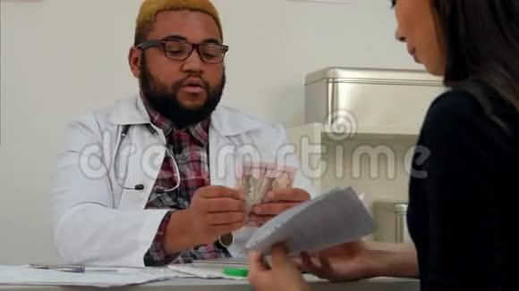 男医生把钱放在口袋里由女病人支付医疗费视频的预览图