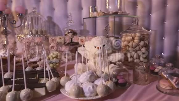 餐厅里的糖果吧孩子们聚会一只白色的泰迪熊脖子上有一只蝴蝶点燃蜡烛泰迪熊视频的预览图