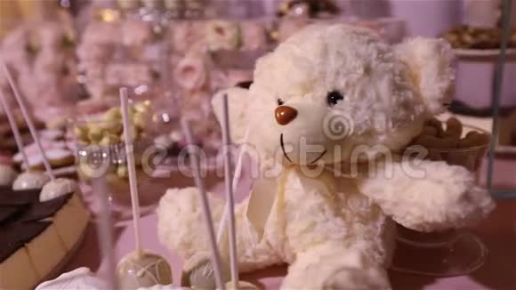 餐馆里的糖果吧孩子们聚会生日一只白色的泰迪熊脖子上有一只蝴蝶点燃蜡烛视频的预览图