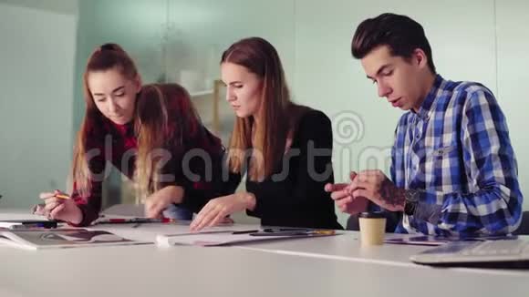 创意办公室室内设计师团队会议年轻的嬉皮士坐在桌旁画素描视频的预览图