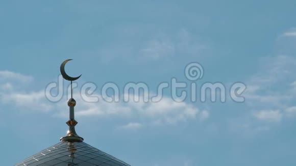 三只灰色的鸽子飞过尖塔上的金色月牙从穆斯林清真寺顶部移动的云层的特写视频的预览图