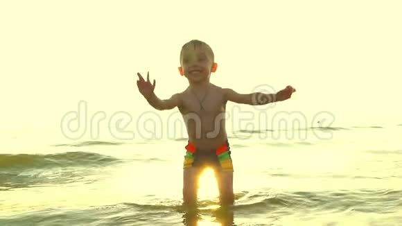 这孩子正在海边玩耍在下降的背景下慢慢地掉进了水里视频的预览图