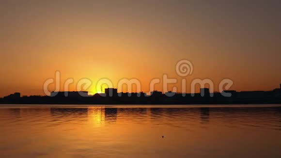 日落时的城市景观建筑物的轮廓和河流中的倒影视频的预览图