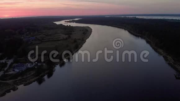 鸟瞰飞越Lielupe河在尤尔马拉拉脱维亚春天2019年日出期间深红色紫罗兰和粉红色的天空视频的预览图