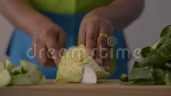 近镜头的女人手切卷心菜在木制的切割板上健康的食物在桌子上视频的预览图