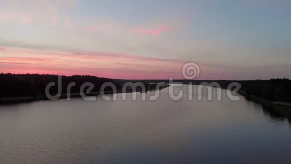 鸟瞰飞越Lielupe河在尤尔马拉拉脱维亚春天2019年日出期间深红色紫罗兰和粉红色的天空视频的预览图