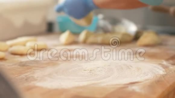 在面包房的糕点烘烤前面包师在桌上擀面团视频的预览图