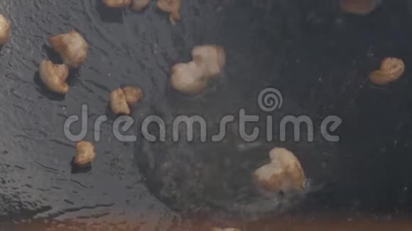 噼里啪啦在大煎锅里翻炒特写肉片用油煎慢动作视频的预览图