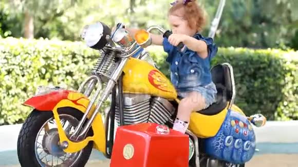 小女孩和骑电动摩托车在公园娱乐视频的预览图