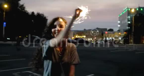 4K停车场前的夜街上带着火花的少女视频的预览图