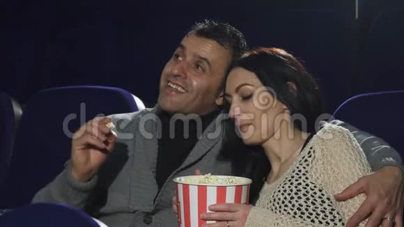 成熟的幸福夫妇在电影院看电影享受他们的约会视频的预览图