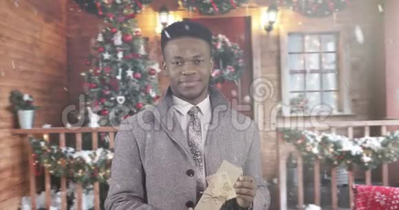 穿着冬衣的非裔美国黑人男子A正在牵着一个带礼物的盒子向前伸展双手视频的预览图