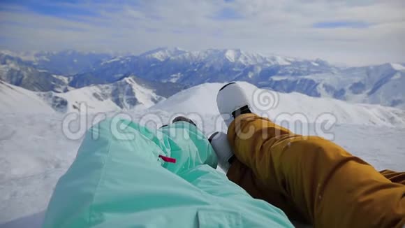 两个有滑雪板的朋友在看雪山视频的预览图