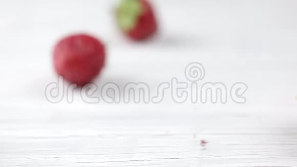 新鲜的草莓从华夫饼杯里倒出来放在浅色的木制背景上浆果草莓水果冰淇淋视频的预览图