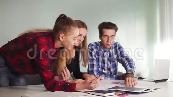 由三人组成的创意商业团队在现代办公室开会一个女人用铅笔指着纸看视频的预览图