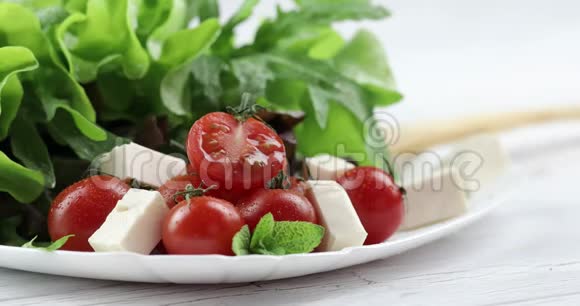 从马拉樱桃番茄和生菜的维生素沙拉手中洒满芳香香料视频的预览图