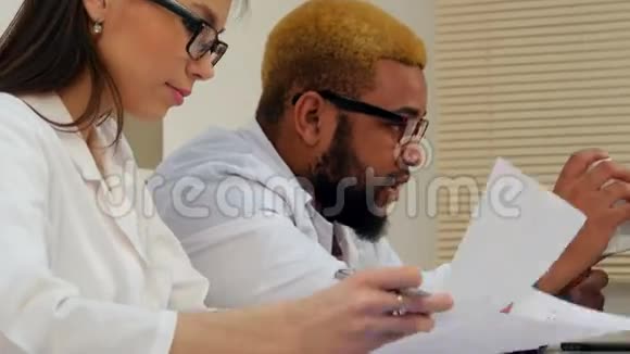 美国黑人男医生和女护士通过视频电话给笔记本电脑开药视频的预览图