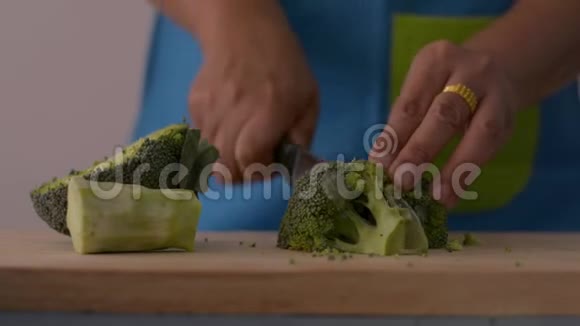近距离拍摄女性手切花椰菜在木切割板上健康食品在桌子上视频的预览图