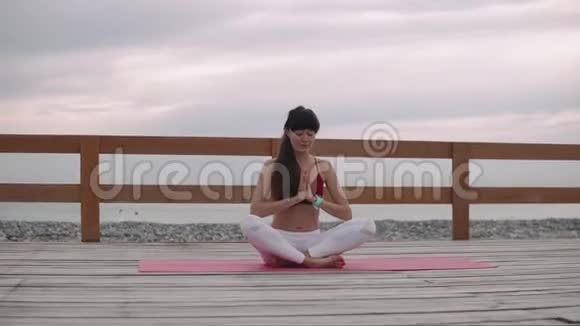 约吉女坐在海边的莲花位置上沉思视频的预览图