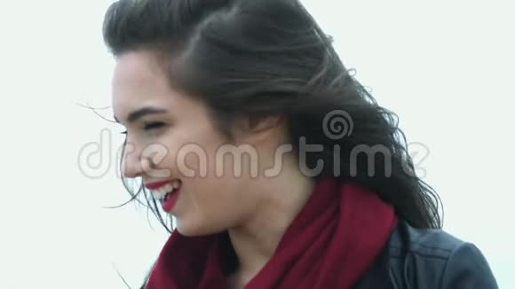 肖像美丽的女人带着白色的微笑在风的黑发上移动视频的预览图