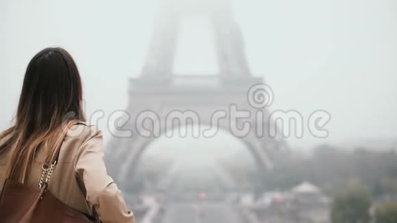 在雾蒙蒙的早晨法国巴黎埃菲尔铁塔附近年轻时尚的女人在市中心散步视频的预览图