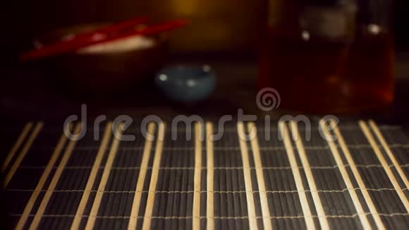 在黑暗的背景上特写寿司垫和棍子竹制寿司席前在寿司吧东方概念视频的预览图