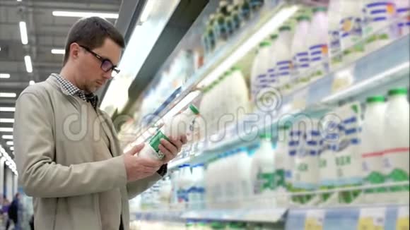 一个成年人在商店里挑选产品他认为一瓶牛奶视频的预览图