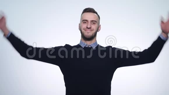 快乐英俊的年轻人微笑着双手放在脑后被孤立在白色的背景上视频的预览图