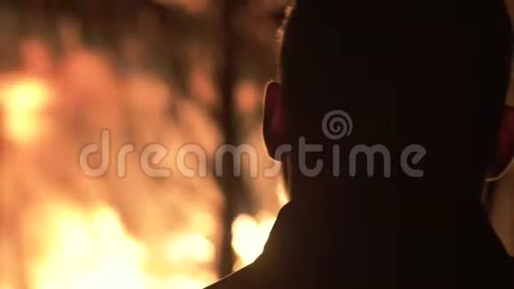 一个火背景的人一个晚上在燃烧的房子里视频的预览图