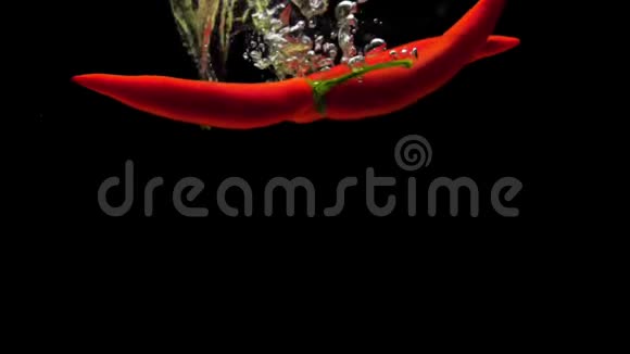 红辣椒在黑色背景下落入透明水视频的预览图
