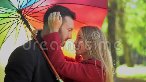 在彩虹伞下散步的情侣视频的预览图