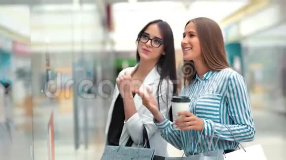 两个美女朋友在商场的店面后面讨论一些事情视频的预览图
