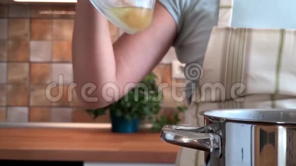 女人正在厨房的平底锅里倒橄榄油慢动作视频视频的预览图