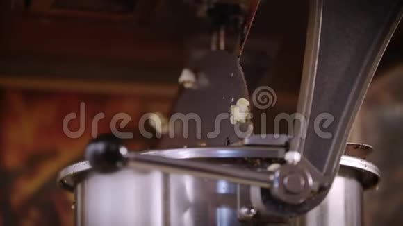 女人在爆米花机里倒玉米粒爆米花生产过程视频的预览图