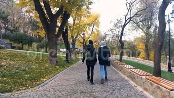年轻的女孩正在秋天的公园里散步视频的预览图
