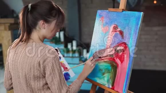 艺术家在工作期间正在蓝色背景上用粉色火烈鸟作画视频的预览图