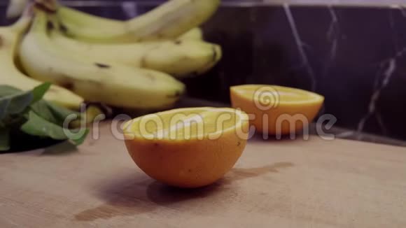 一位厨师在切菜板上切橙子的一半视频的预览图