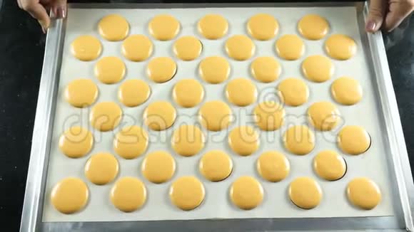 煮熟的马卡龙挤压糕点奶油或面团的形式黑色背景4k视频的预览图