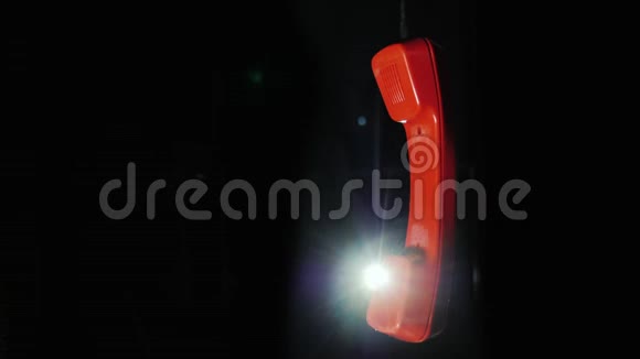 红色电话接收器从复古电话挂在电线上的黑色背景视频的预览图