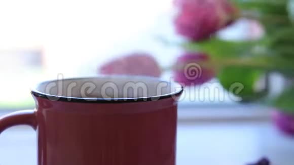 粉红色陶瓷杯中的热沸茶配对窗台视频的预览图