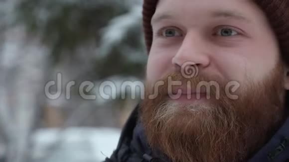 在森林里一个戴着帽子和夹克抽着烟的年轻人留着胡子的嬉皮士视频的预览图