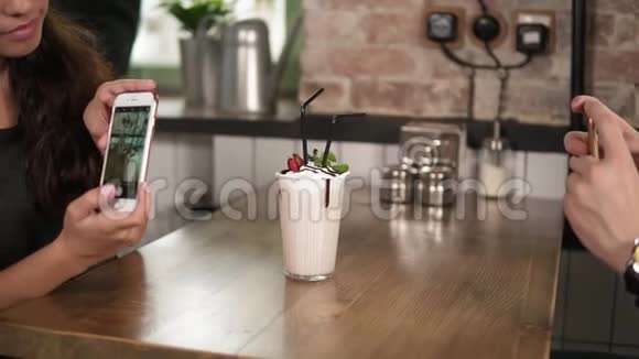 男人和女人的手拿着一个杯子的照片上面放着樱桃和稻草放在木桌上视频的预览图
