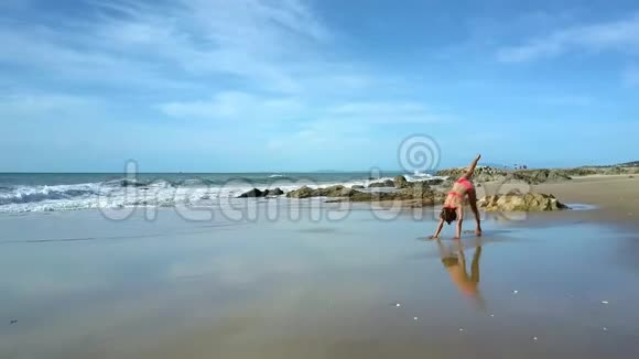 沙滩女孩站在瑜伽姿势上的泡沫波浪翻滚视频的预览图