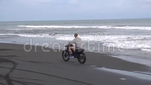 骑摩托车一个人骑着他的山地车在巴厘岛的海滩上视频的预览图
