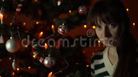 一个年轻的女人自拍坐在装饰好的圣诞树下视频的预览图