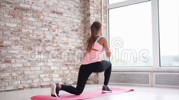 一位年轻女子单脚在健身俱乐部的瑜伽垫上做仰卧起坐视频的预览图